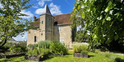 Vue du jardin d'inspiration médiévale avec le Presbytère en arrière plan
